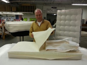 Rory Karpathian, President of Beds by Design, with a mattress made for infants, pictured at his Rochester location, Thursday April 23, 2015. (Photo by: Vaughn Gurganian)